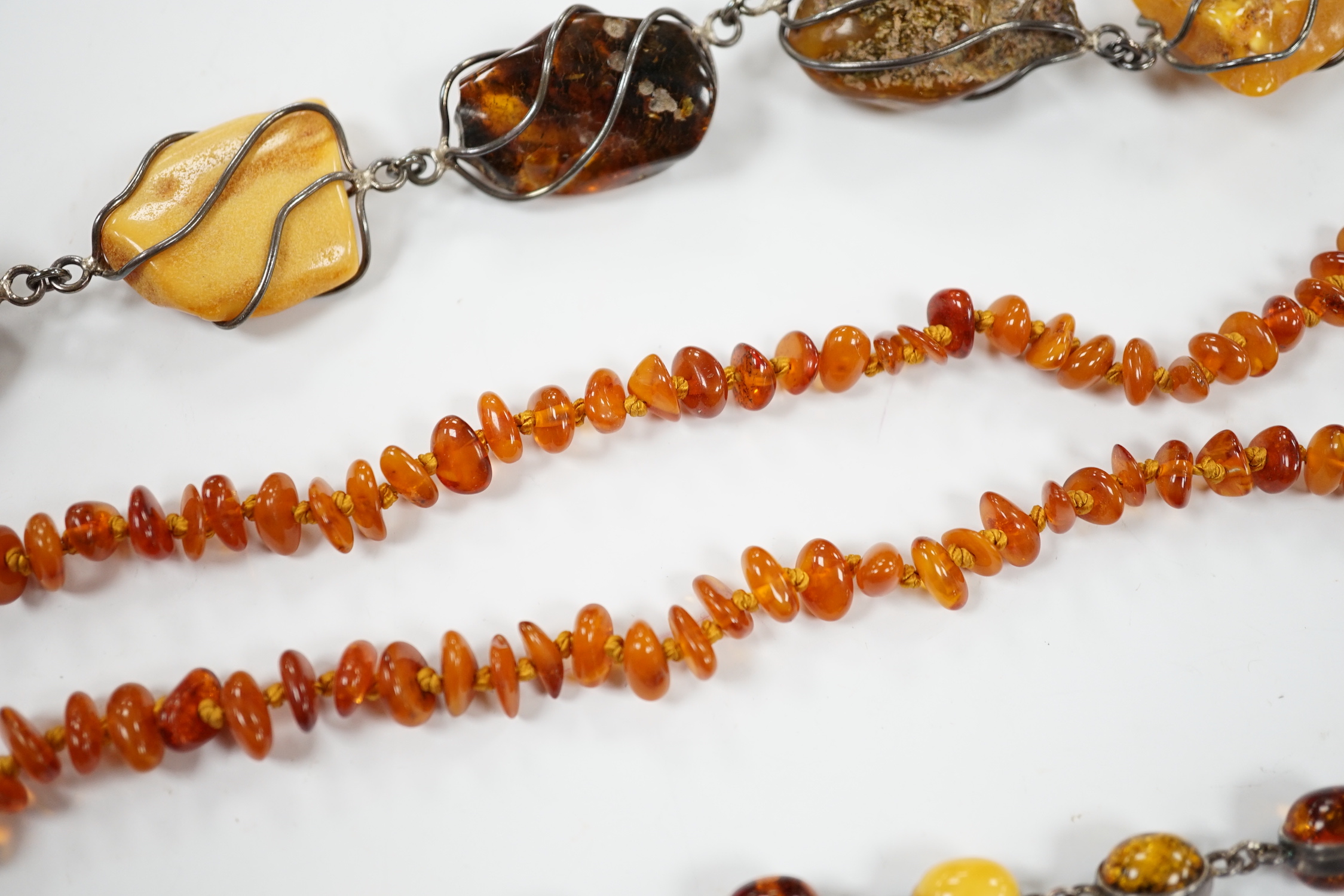 Two white metal and Baltic amber pebble set bracelets, one stamped 925, largest 25cm, a pair of similar drop earrings and an amber necklace.